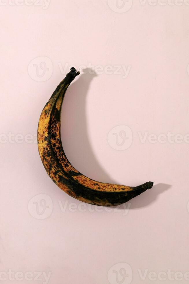 Over Ripe Rotten Banana on Pink Background photo