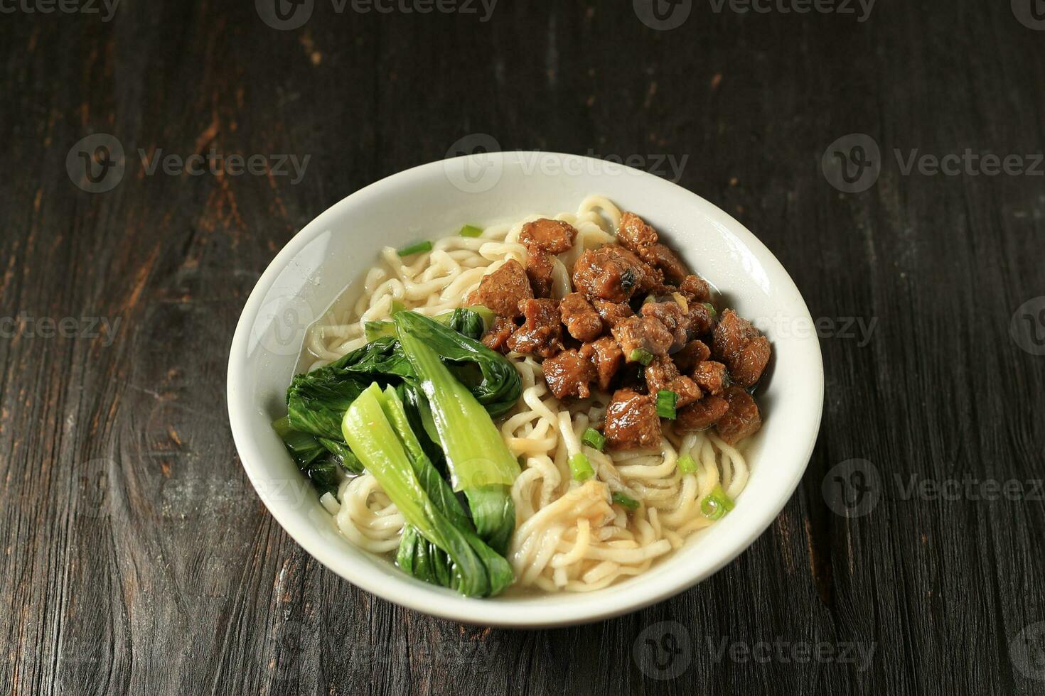 Mie Ayam, Indonesian Popular Street Food with Noodle, Chicken, and Green Vegetables photo