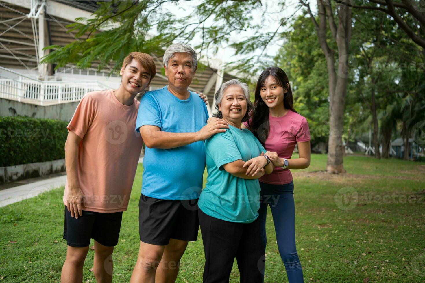 Healthy family group instructors workout in fresh air, and they rest and stand together after morning exercises in park. Outdoor activities, healthy lifestyle, strong bodies, fit figures, health care. photo