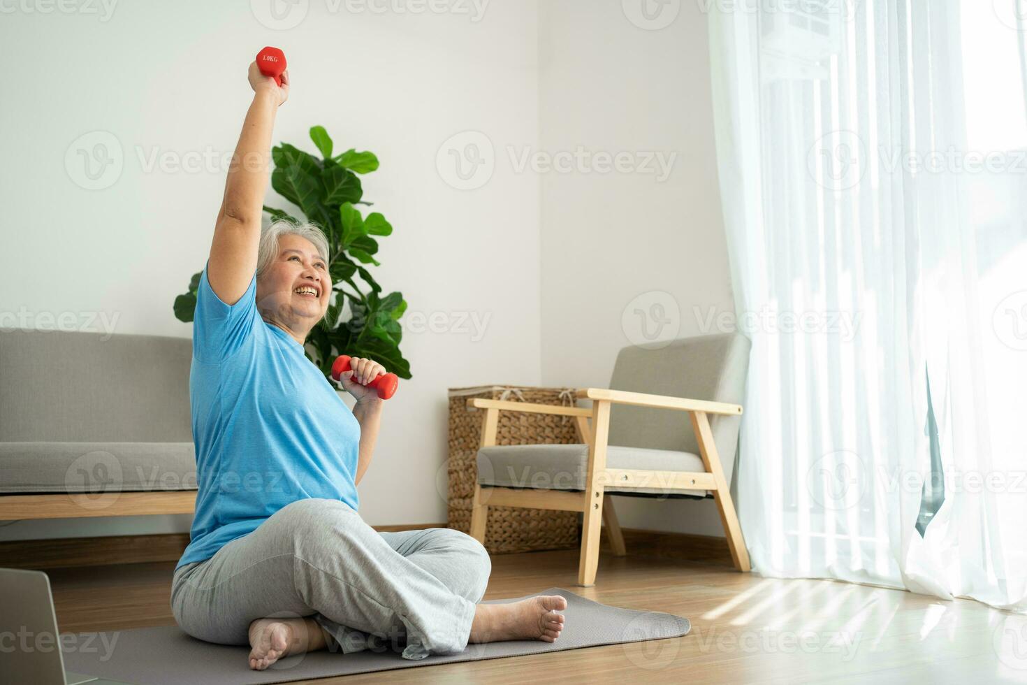 anciana asiática levantando pesas para hacer ejercicio y hacer ejercicio en casa. mujer madura activa haciendo ejercicio de estiramiento en la sala de estar. ejercicio activo y saludable para personas mayores, mayores y mayores. foto