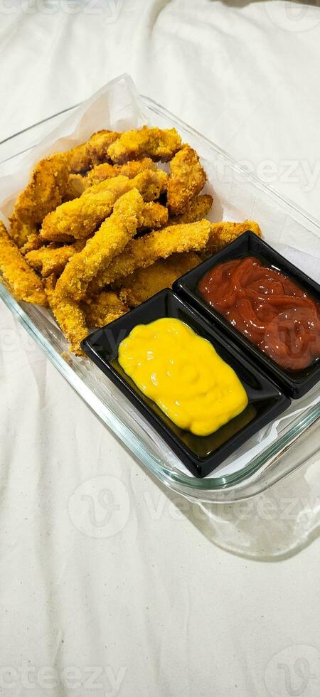 breaded fried chicken strips and sauces photo