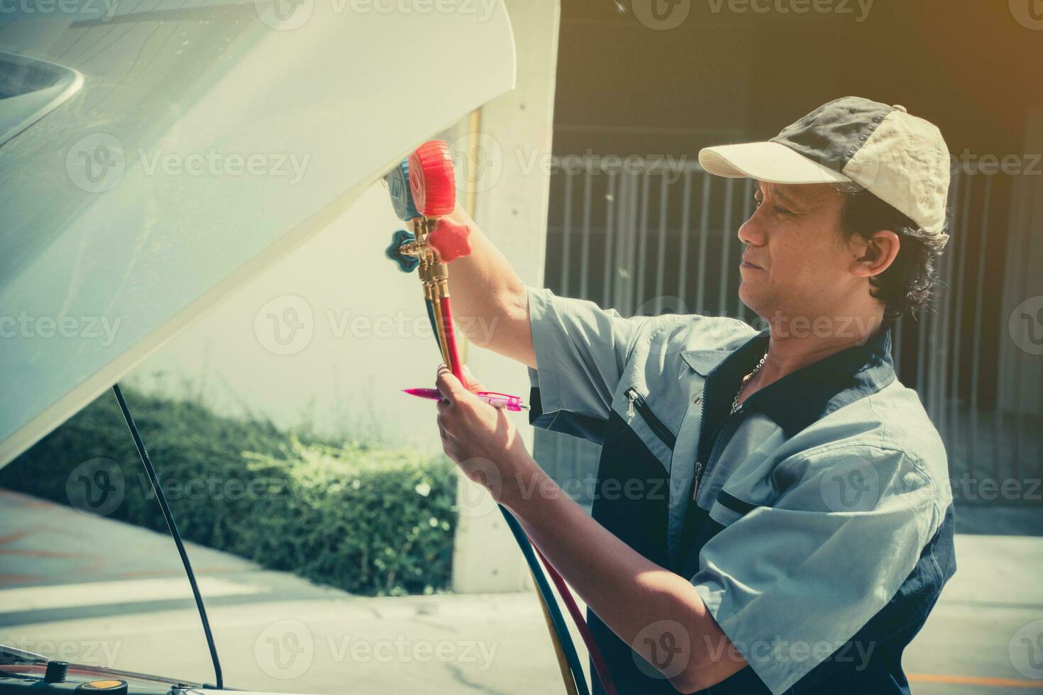 Auto repairman checks the engine and cooling system before traveling on a long holiday. Concept of Car care and maintenance from experts photo