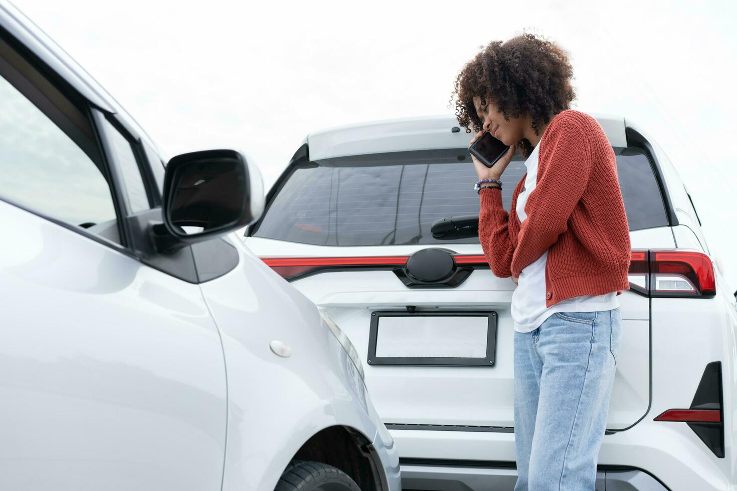 Asian women driver check for damage after a car accident before taking pictures and sending insurance. Online car accident insurance claim after submitting photos and evidence to an insurance company.