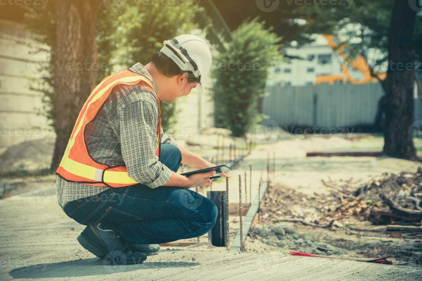 Engineering, wearing a helmet and holding tablets, sitting down To check the structure of the corridor in the park photo