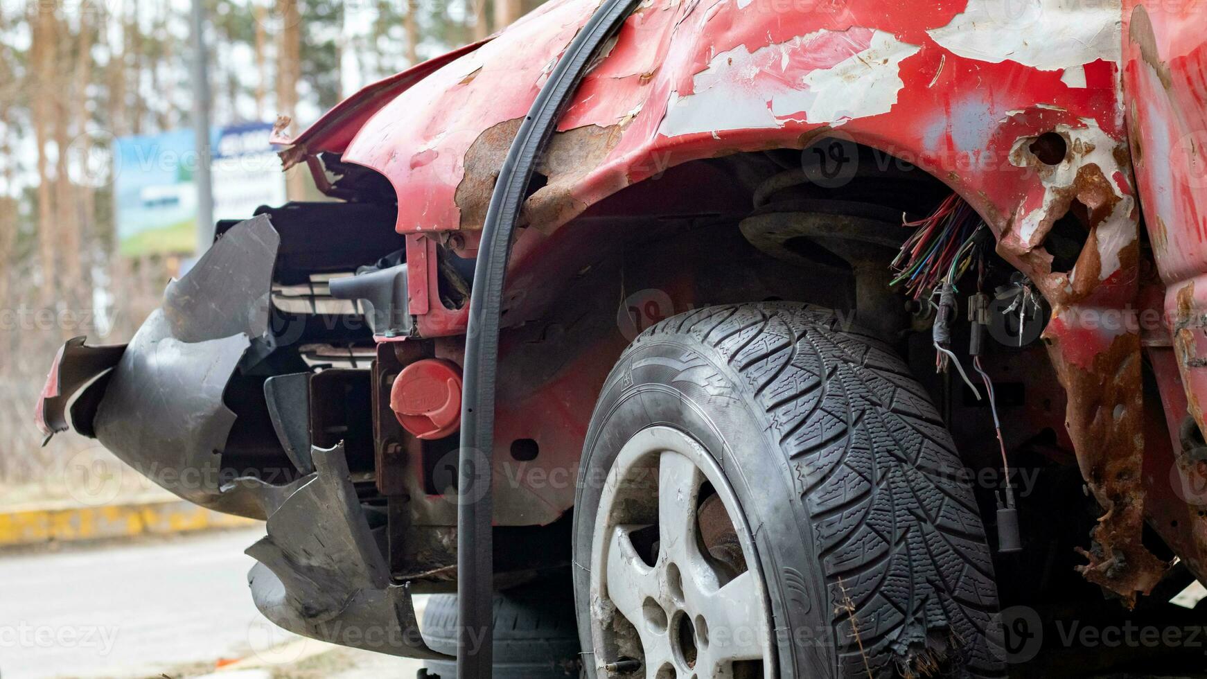 Broken rumpled red car after a severe accident with a skewed body, after a powerful blow. Accident on the street, damaged car after a collision in the city. Auto accident. Broken car on the street. photo