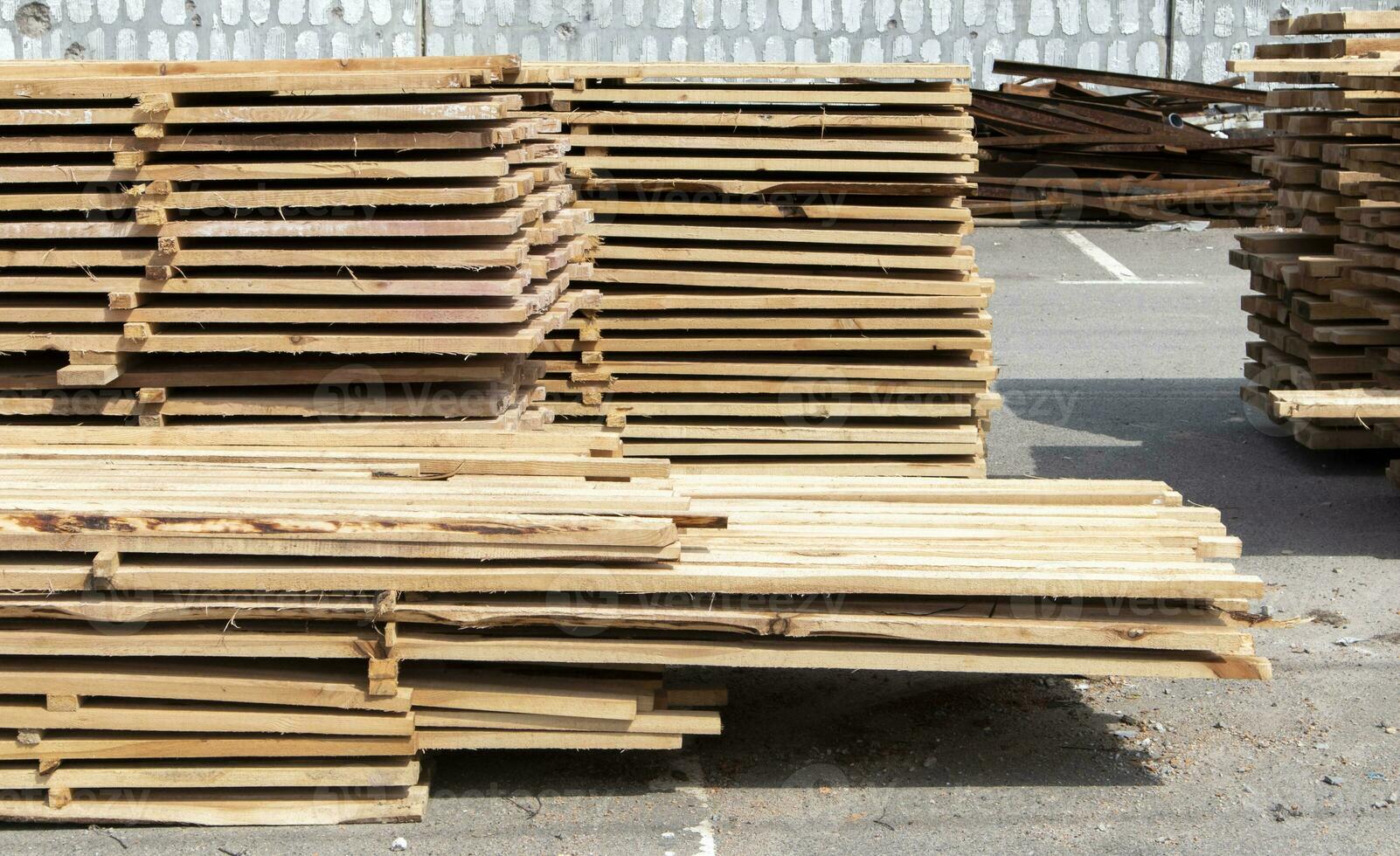 Pile of stacked wooden planks at a construction site. Wooden boards, lumber. Industrial edged timber. Wooden rafters for the repair or construction of a private house. Roofing and joinery lumber. photo