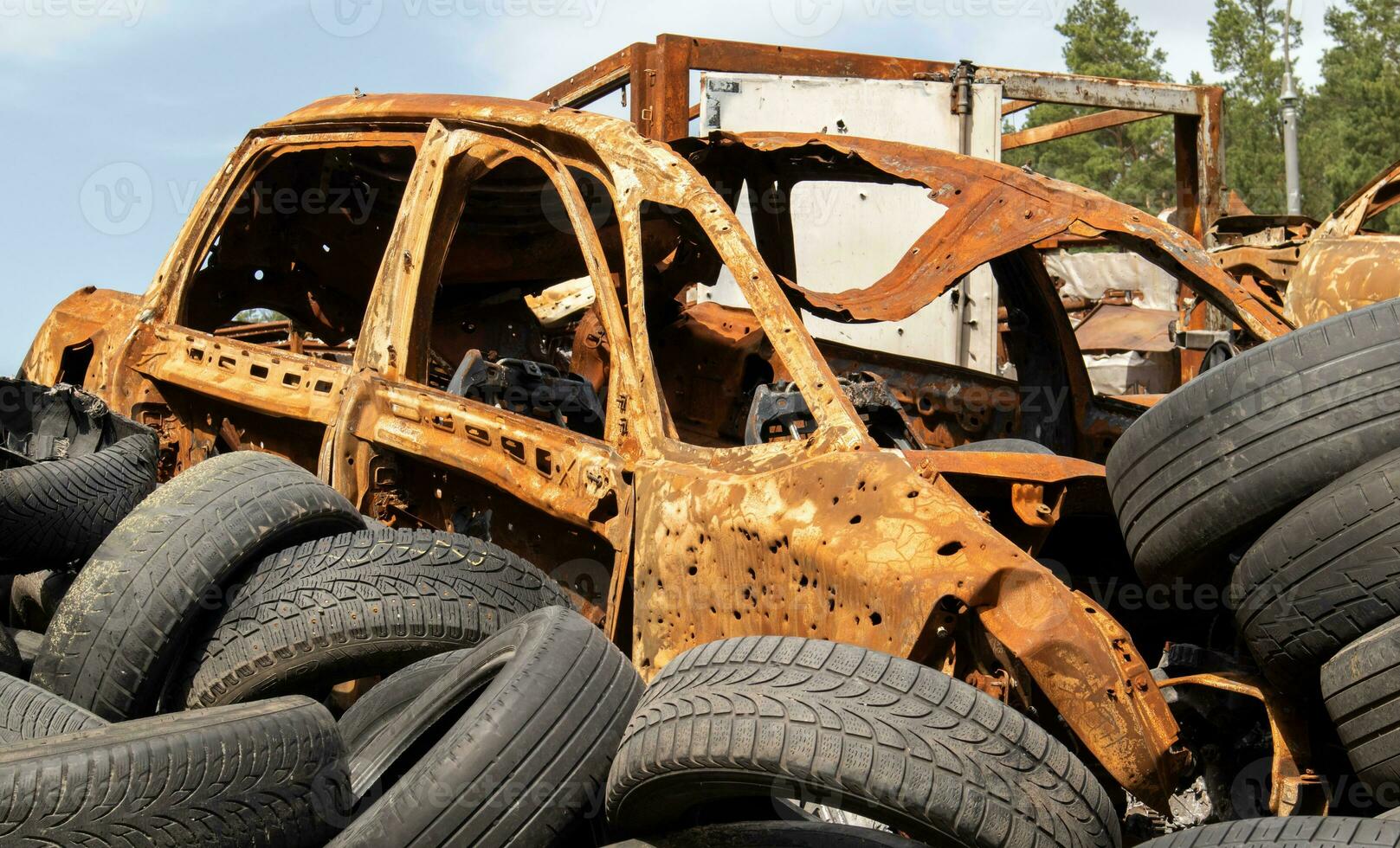 Garbage from a pile of black old car tires. Environmental pollution. Ecological problems. Old car tires thrown into an industrial landfill for recycling. Reuse of worn rubber tires. photo