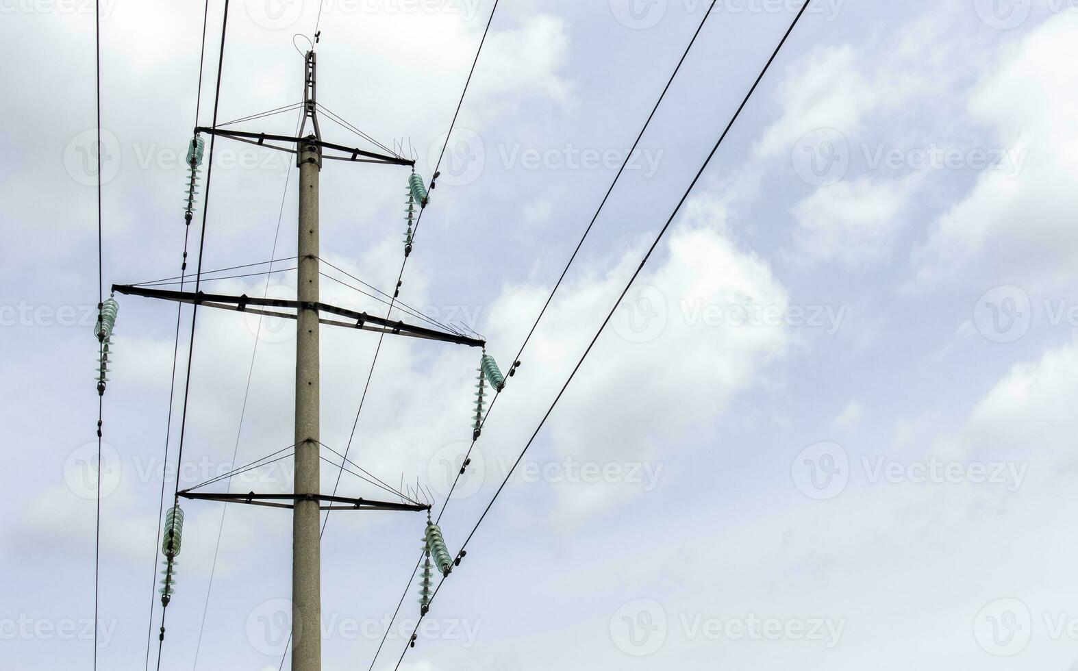High voltage electrical tower against the sky. High voltage power lines. Electrical distribution station. The passage of the overhead line wire supports carrying light and heat into the house. photo