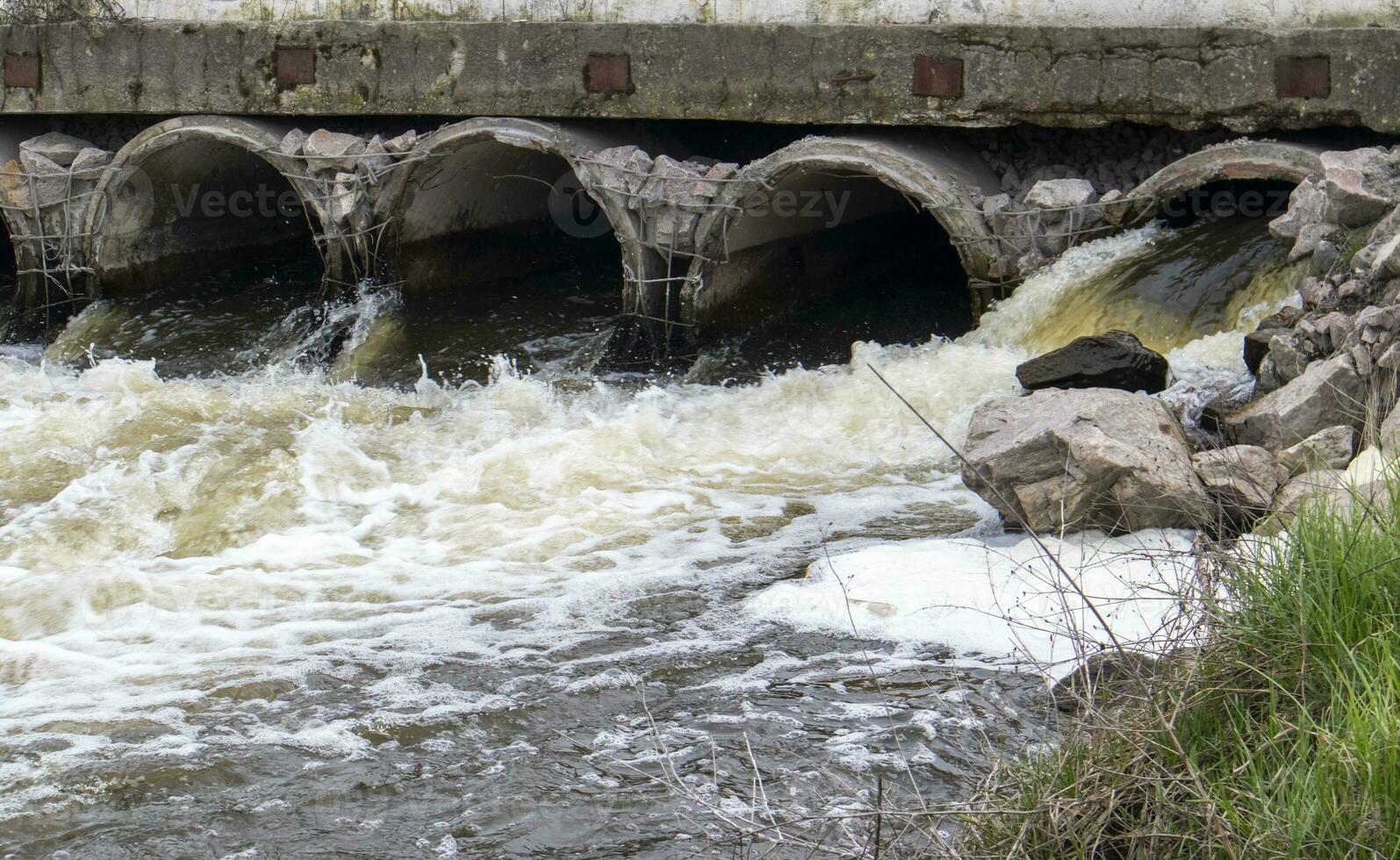 un hormigón tubo ese lleva maloliente, contaminado aguas residuales dentro el río mediante tubería. contaminación de el ambiente y agua cuerpos. ecológico catástrofe peligroso residuos agua. foto