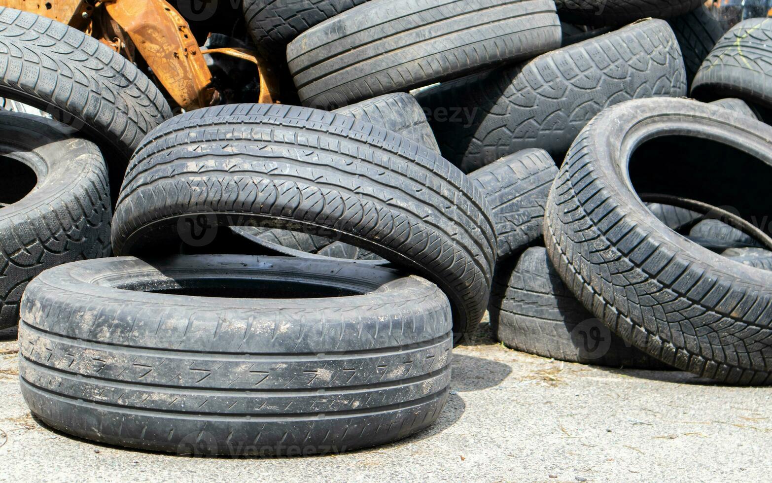 Industrial dump for the processing of used tires and rubber tires. Pile of old tires and wheels for rubber recycling. Tire dump. Recycling of used tires. Produced reclaimed tire rubber. photo