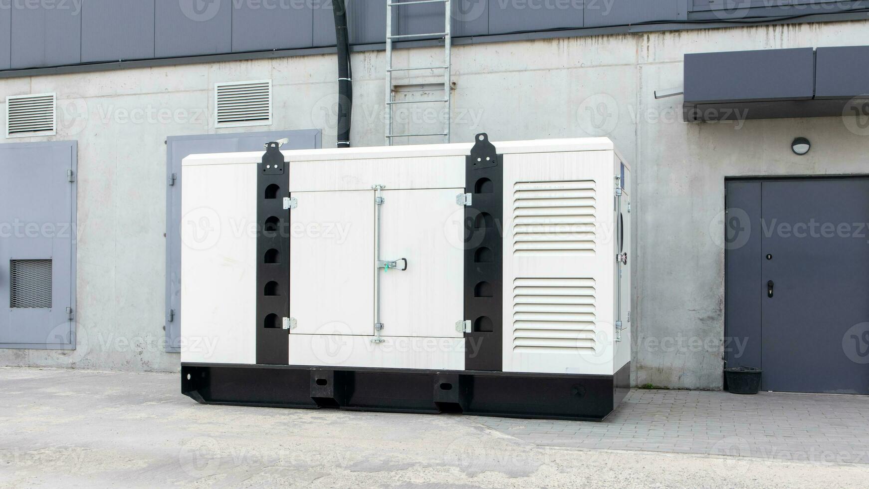 White auxiliary diesel generator for emergency power supply. Industrial generator connected to the control panel by a cable wire. Backup power supply of the generator. photo