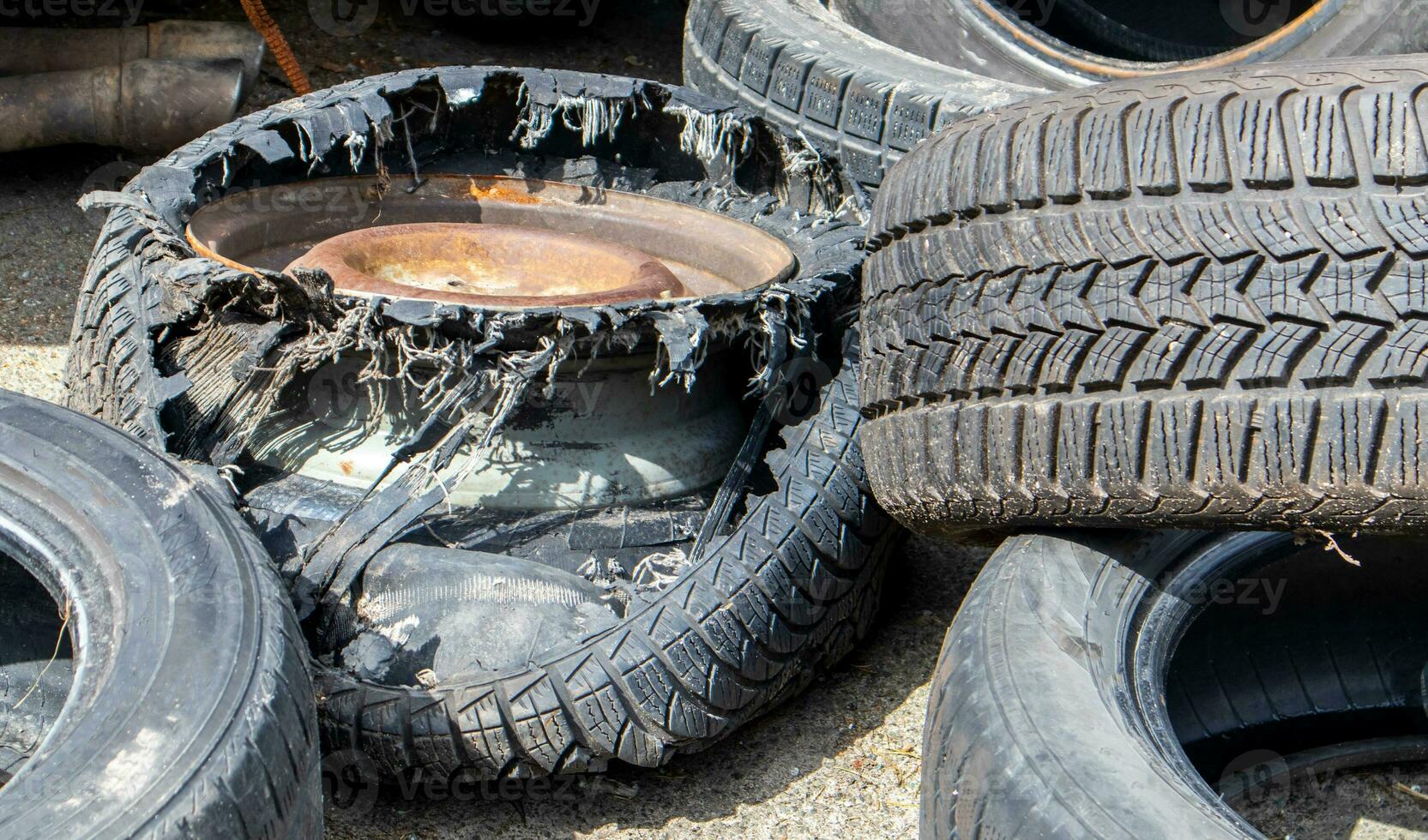 Industrial dump for the processing of used tires and rubber tires. Pile of old tires and wheels for rubber recycling. Tire dump. Recycling of used tires. Produced reclaimed tire rubber. photo