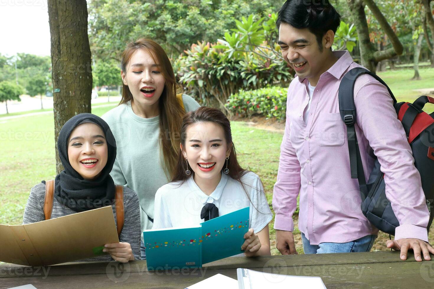 Young asian malay chinese man woman outdoor park  book file folder laptop computer phone sit stand study mingle photo