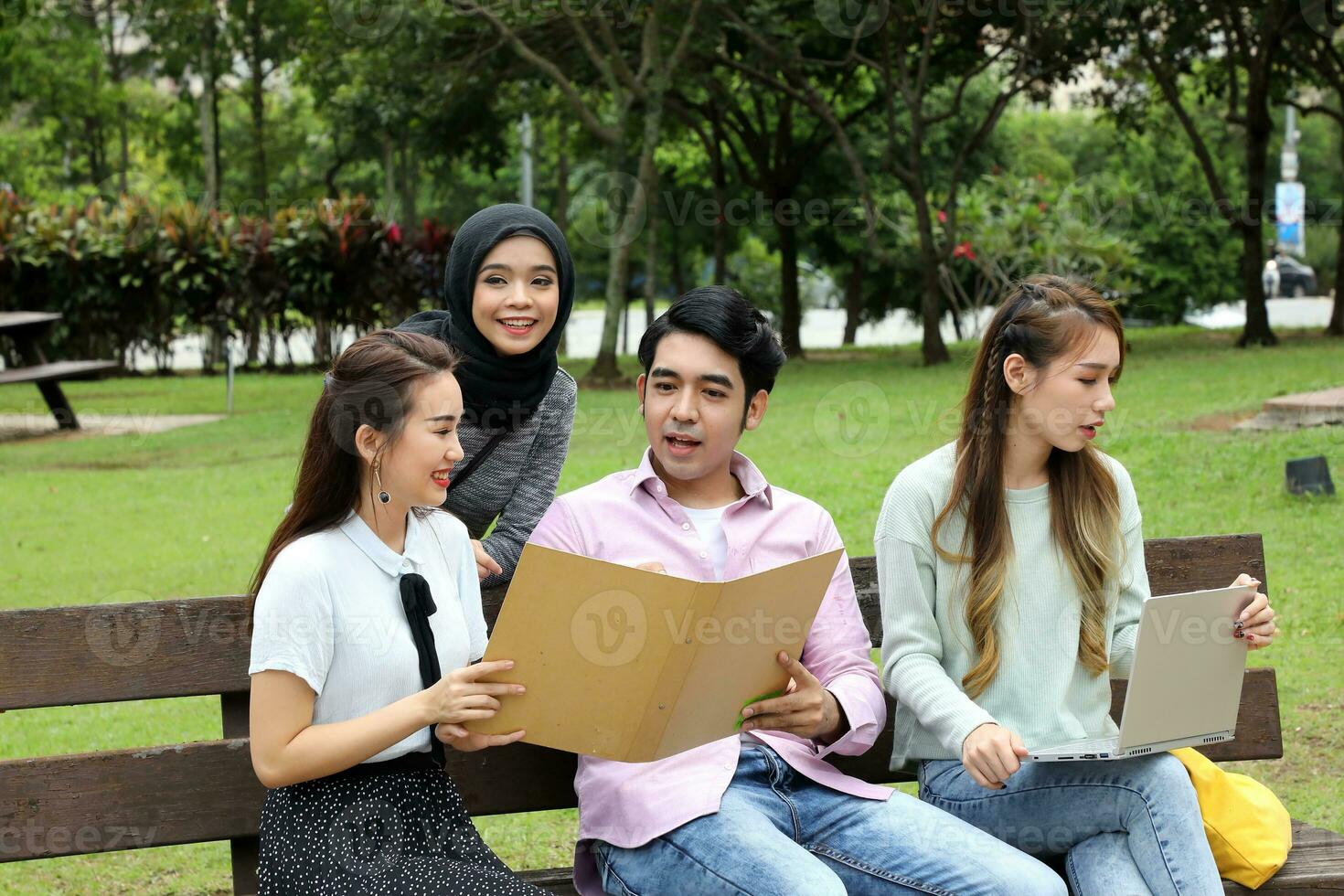 Young asian malay chinese man woman outdoor park  book file folder laptop computer phone sit stand study mingle photo