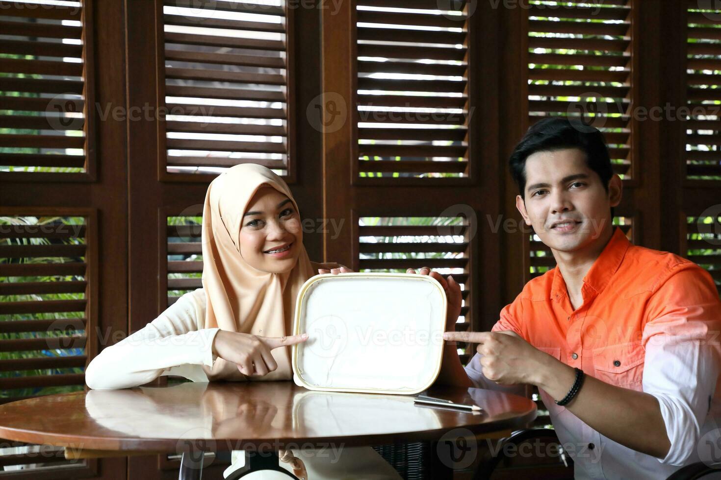Young Asian Malay man woman outdoor green park walk talk discuss mingle photo