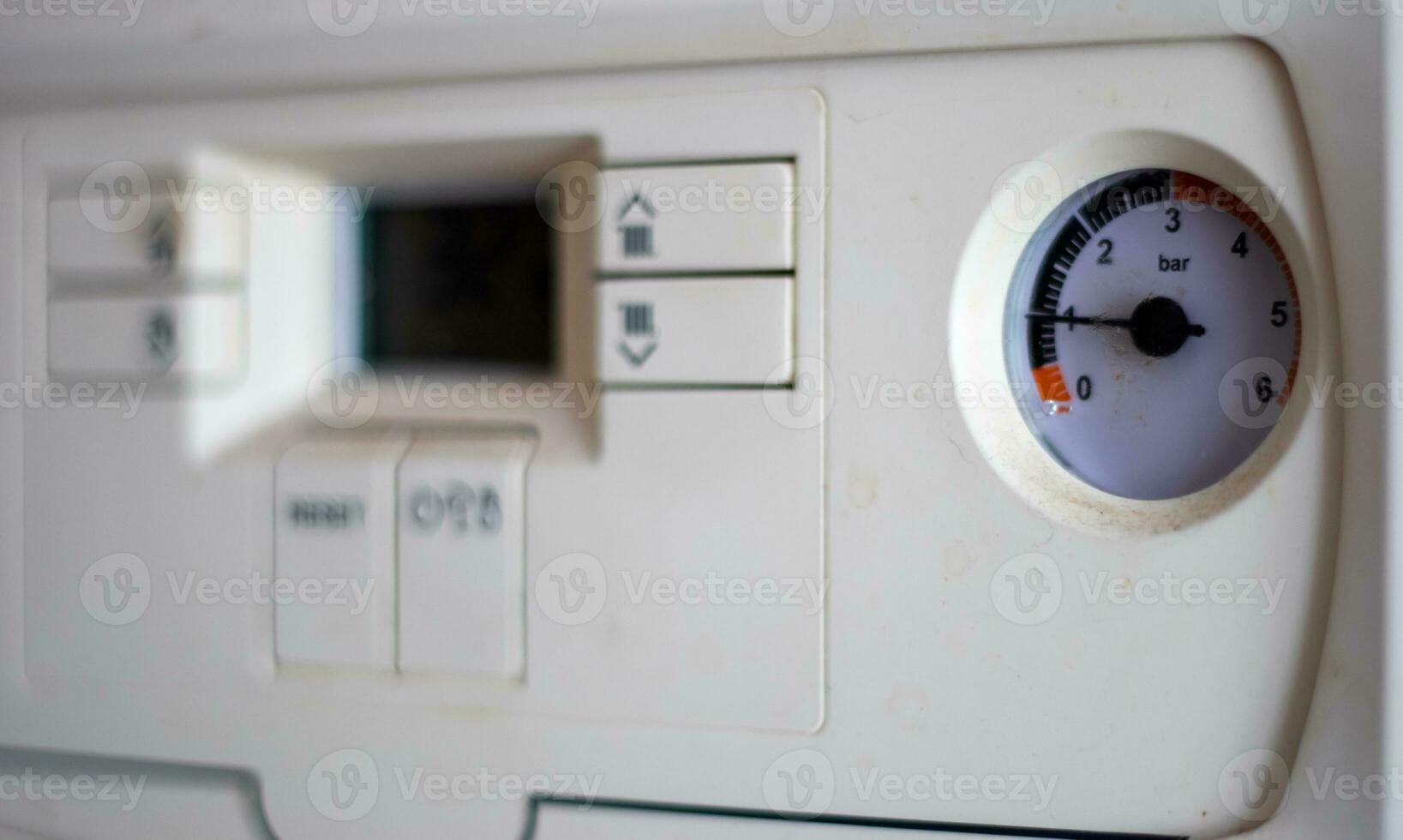 Gas pressure meter on the panel of the heating gas boiler. Symbolic image of the heating season at home. Dial and pressure gauge on combi boiler. Hot water and heating. Boiler accessories. photo