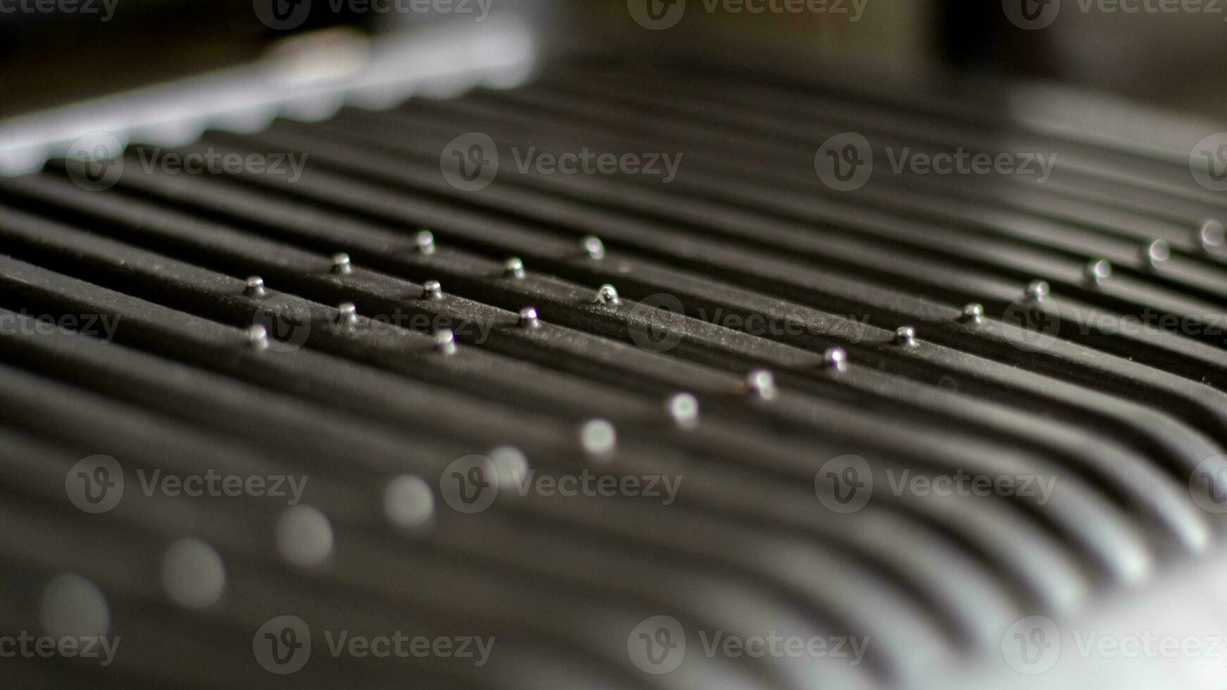 Black electric grill grate, textured background. The surface of the electric grill. Pollution of the surface of the electric stove. Close-up of a home electric grill, in the kitchen. BBQ. photo