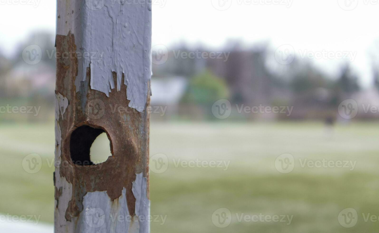 Bullet hole in the pipe. War in Ukraine. A hole from a shell fragment. Consequences of the war. Holes from shots on a metal pipe. photo