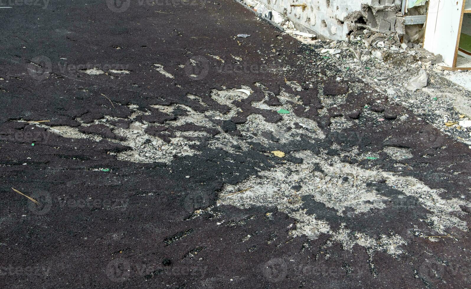 War in Ukraine. Funnel from the explosion in the asphalt. The trace left by the explosion of an artillery shell. Consequences of the rocket attack. photo