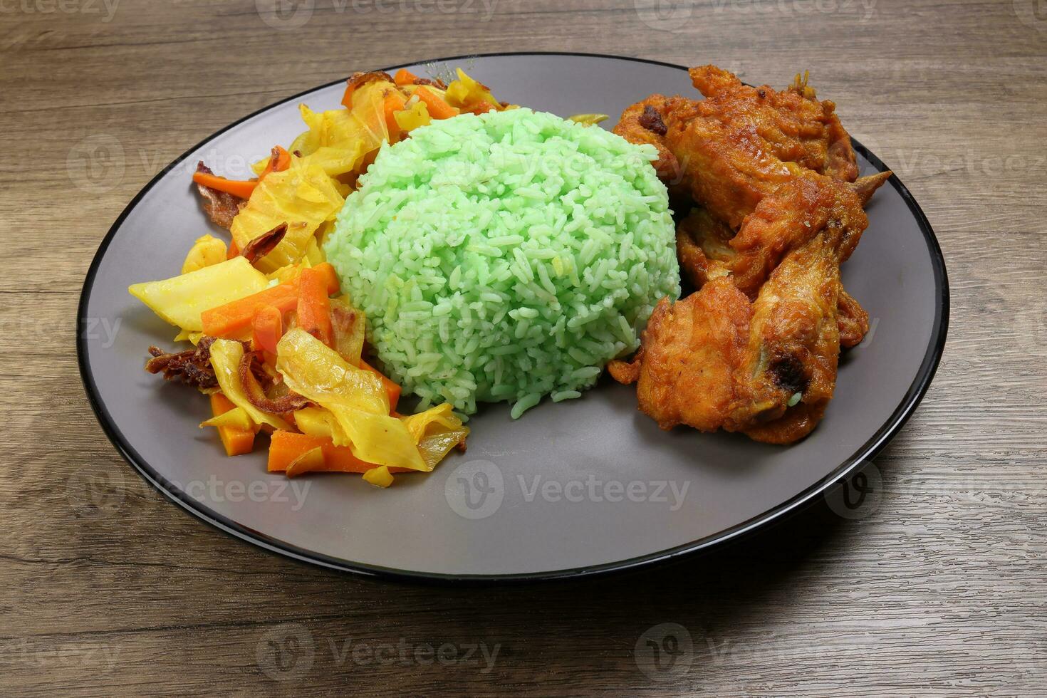 al vapor verde arroz condimentado profundo frito pollo repollo Zanahoria vegetal warung nasi ayam goreng en oscuro gris plato de madera antecedentes foto