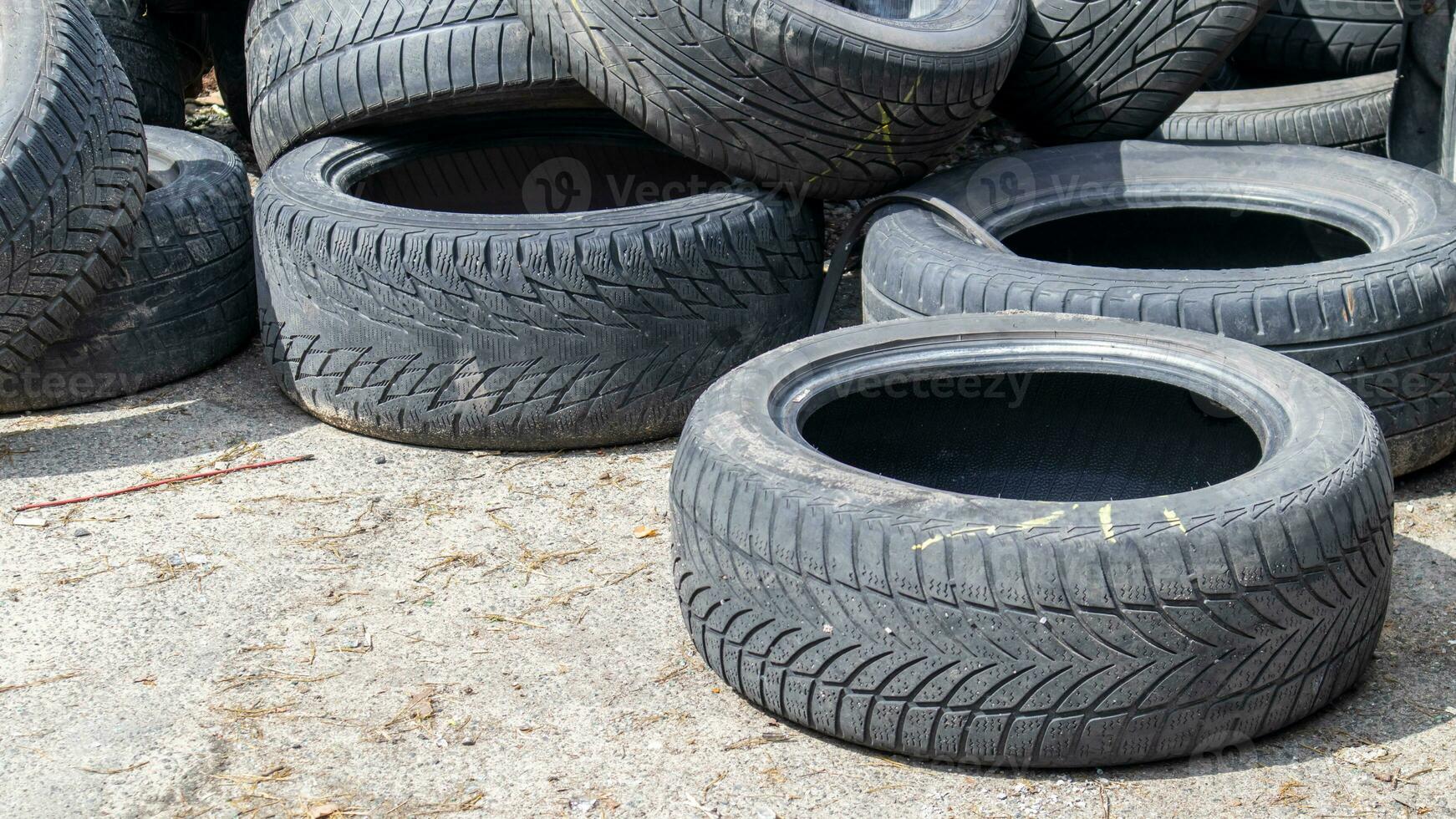 Worn wheels for recycling. Plant for burning tire dumps. Mountain of old tires. Used wheel junkyard. Pile of old tires and wheels for rubber recycling. Recycling concept. photo