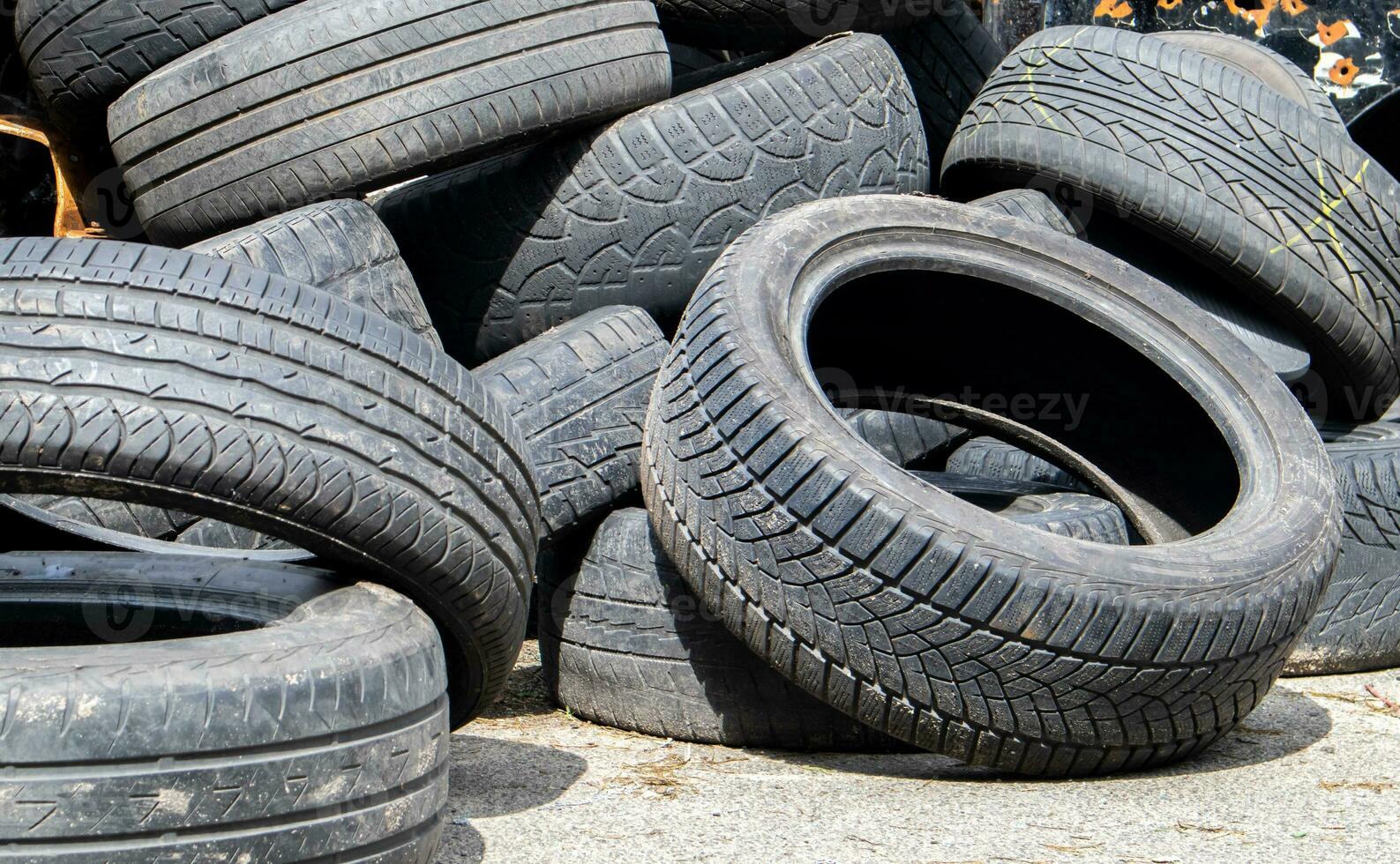 Industrial landfill for recycling used tires and rubber tires. Old used tires. A dump full of used car tires. The concept of recycling and environmental protection. photo