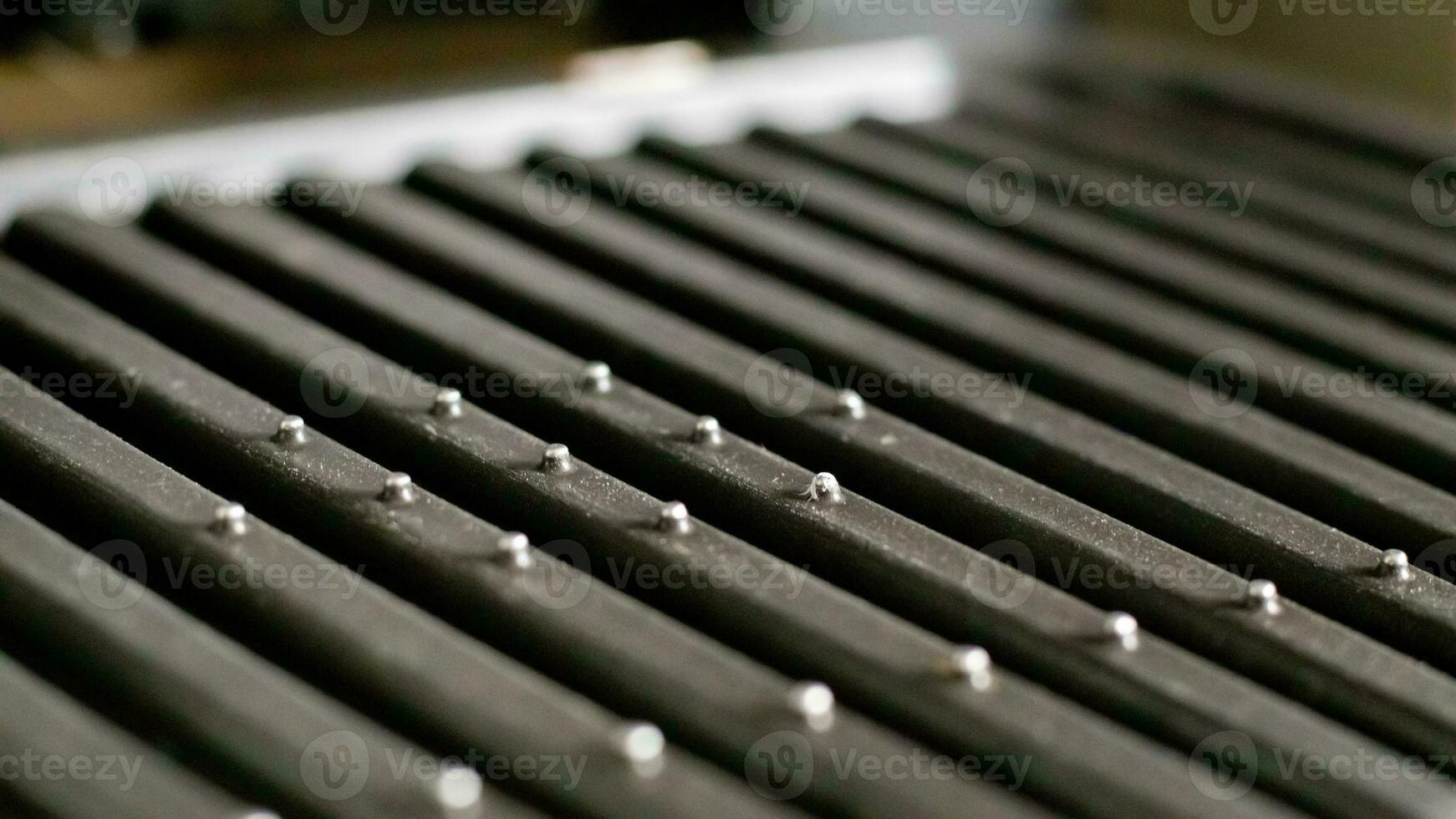 Black electric grill grate, textured background. The surface of the electric grill. Pollution of the surface of the electric stove. Close-up of a home electric grill, in the kitchen. BBQ. photo