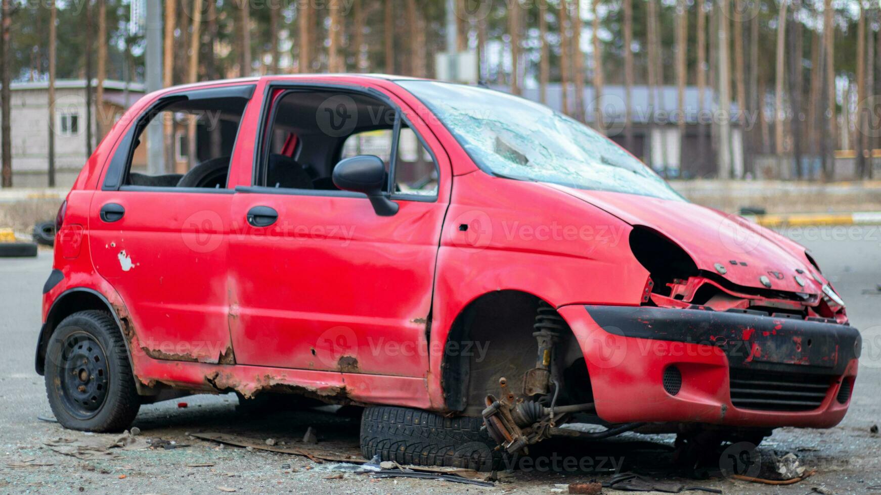 oxidado y roto rojo abandonado coche en el ciudad calle. abandonado antiguo coche accidente al aire libre. antiguo abandonado oxidado coche sin ruedas en el lado de el la carretera. foto