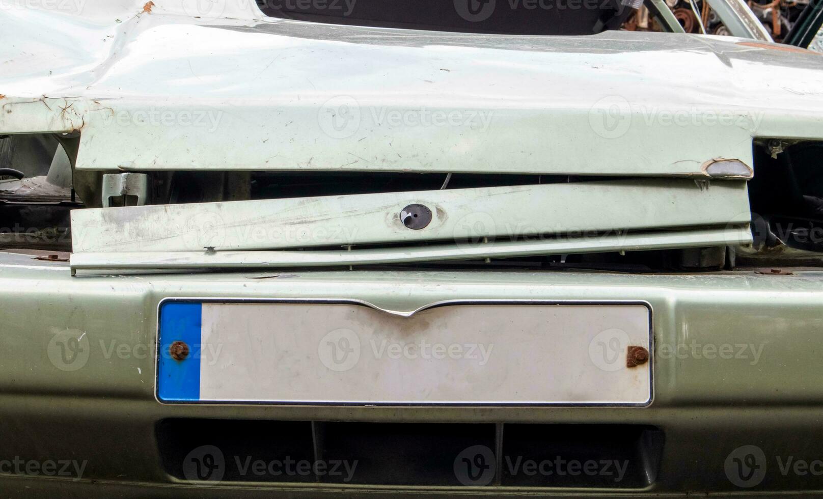 The front of the car with damage to the bumper after the accident. Empty license plate. Close-up of the surface of the license plate in front of the car, square license plate of the car. photo