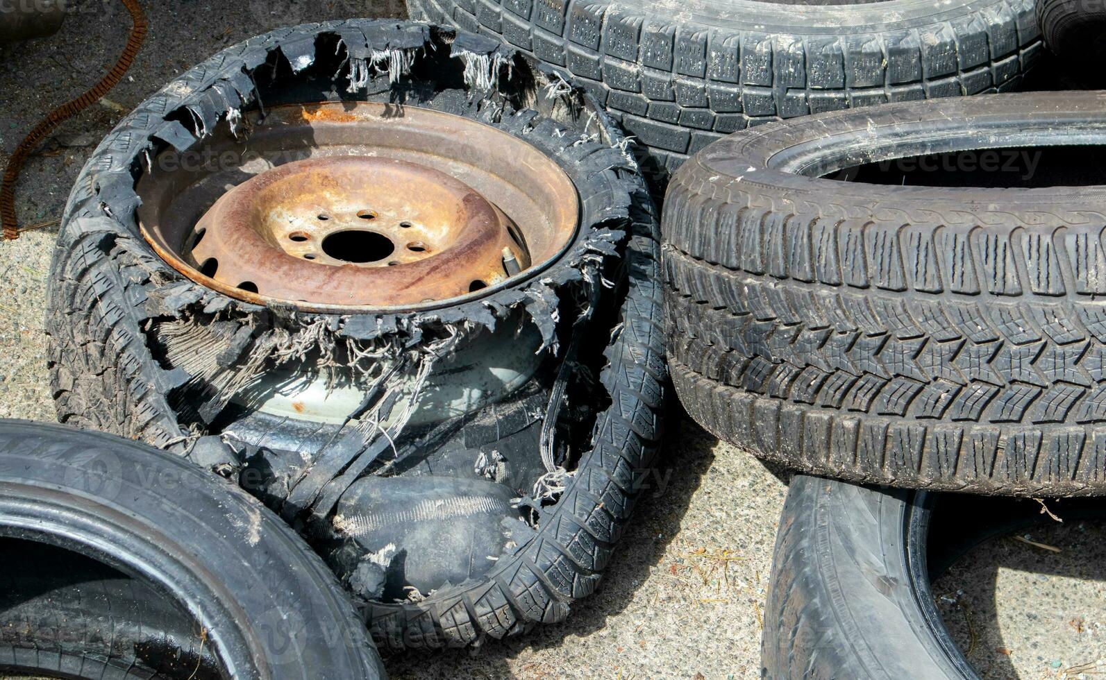 Worn wheels for recycling. Plant for burning tire dumps. Mountain of old tires. Used wheel junkyard. Pile of old tires and wheels for rubber recycling. Recycling concept. photo