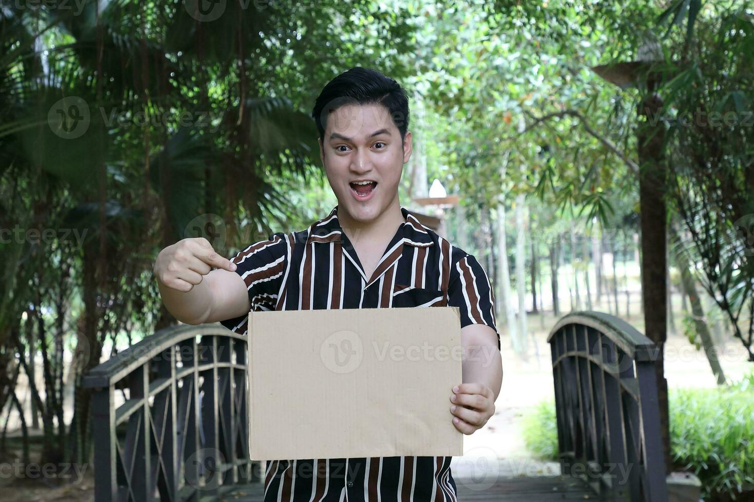 Young Asian Malay man woman outdoor green park walk talk discuss mingle photo
