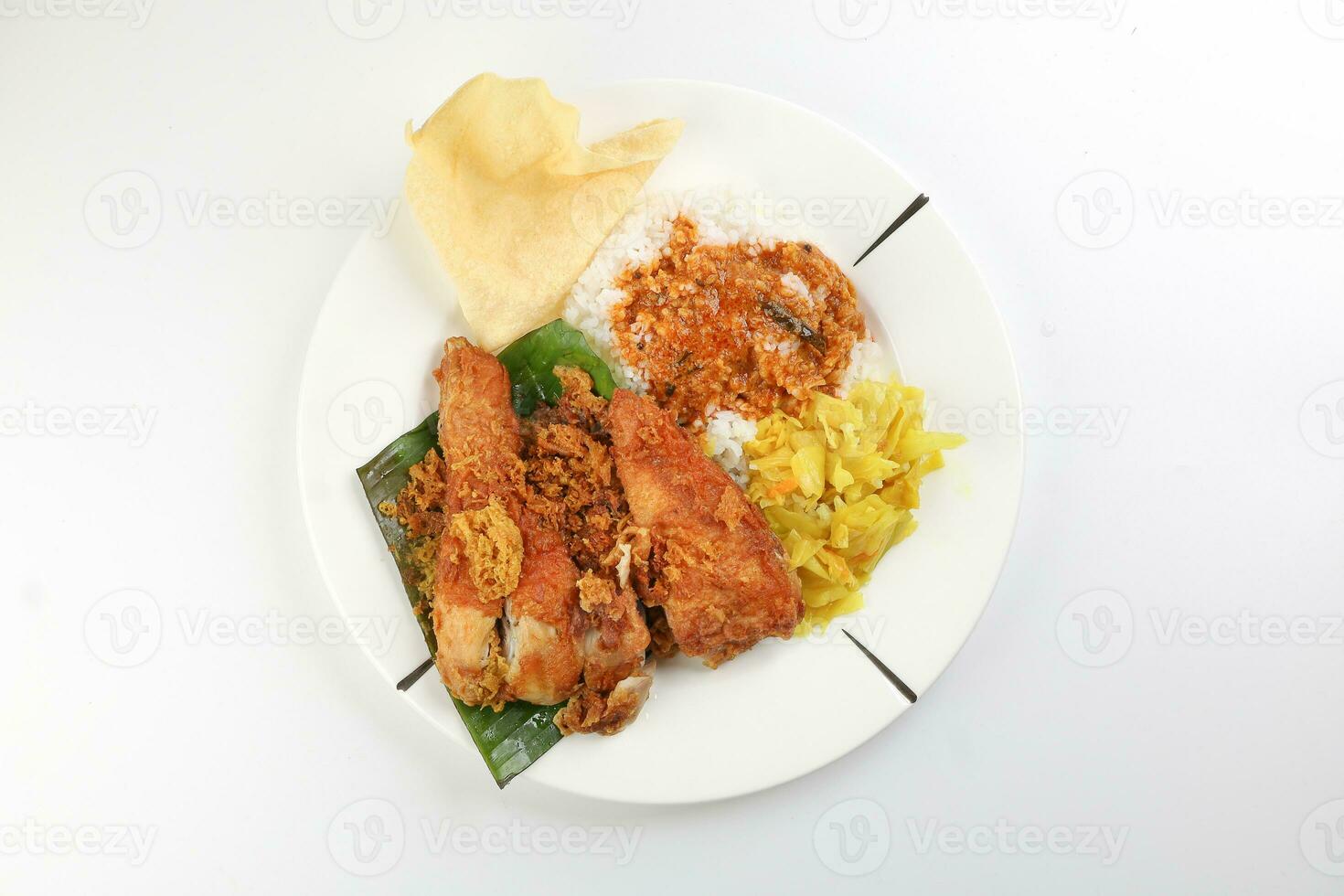 Traditional Malaysian Indian food white rice cabbage vegetable meat deep fried chopped chicken leg topped up with spicy mix gravy white background photo