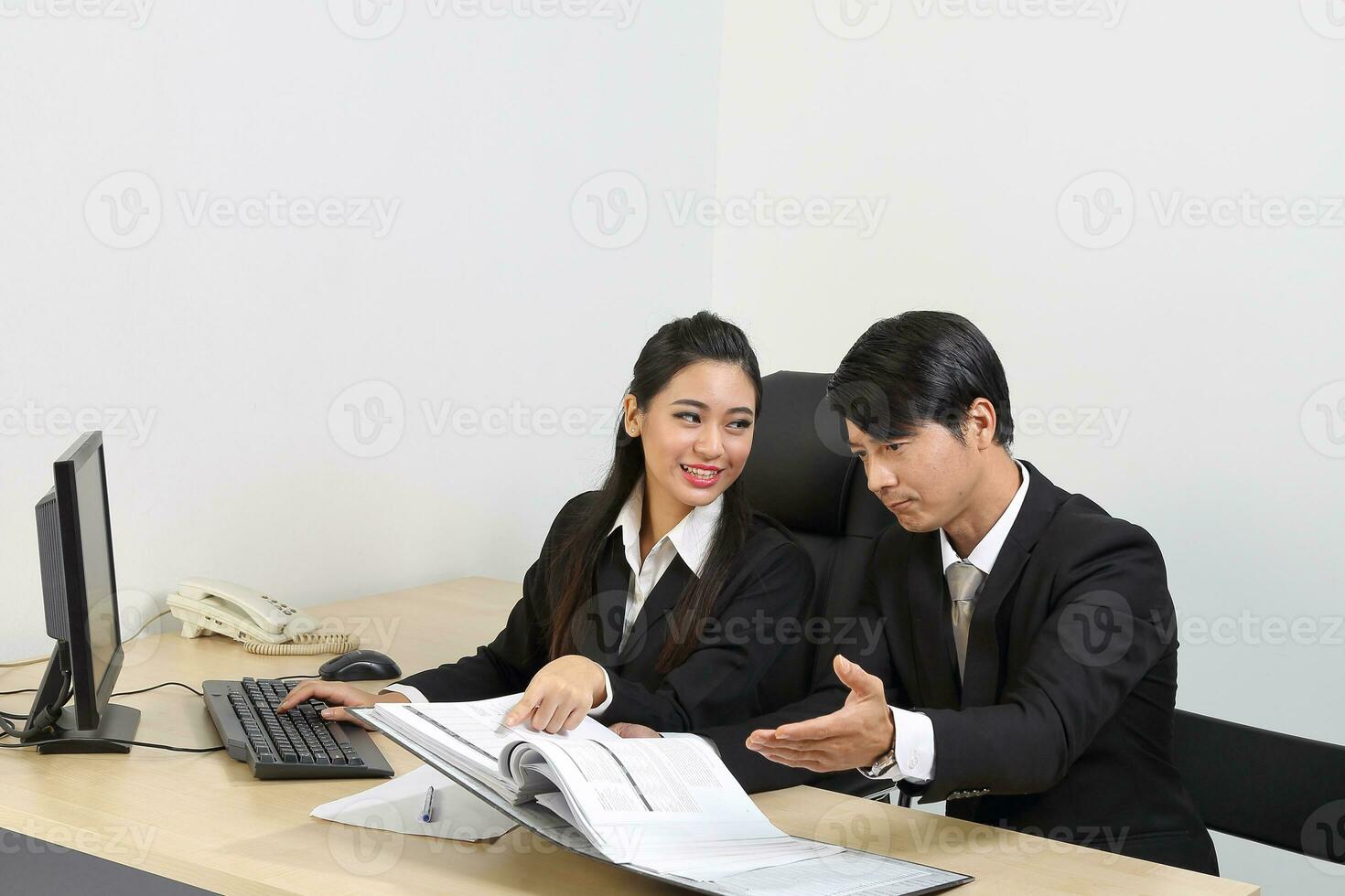 Young Asian male female wearing suit sitting at office desk thinking meeting disucsing sign document agreement photo