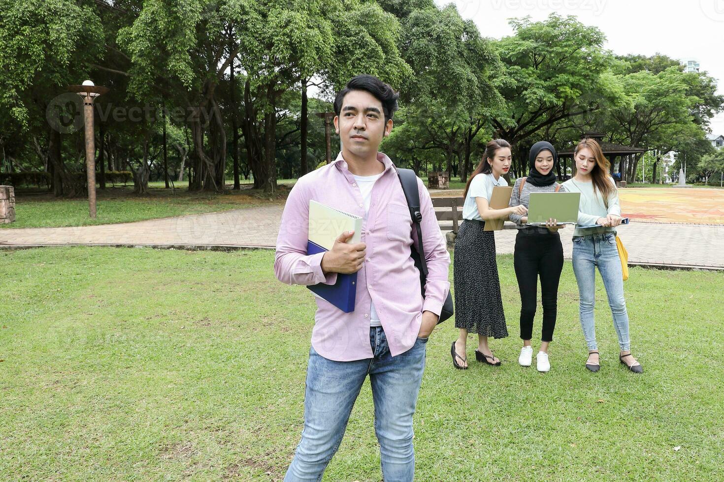 Young asian malay chinese man woman outdoor park walk stand study talk discuss point laptop file book backpack happy forward photo