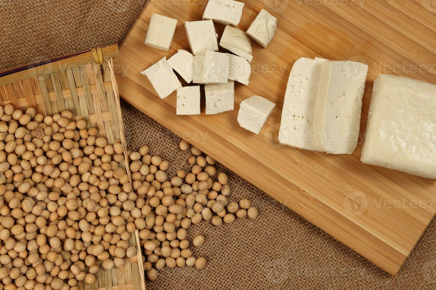 Soyabeans curd tofu soya beans flowing bamboo sieve wooden board on jute background photo