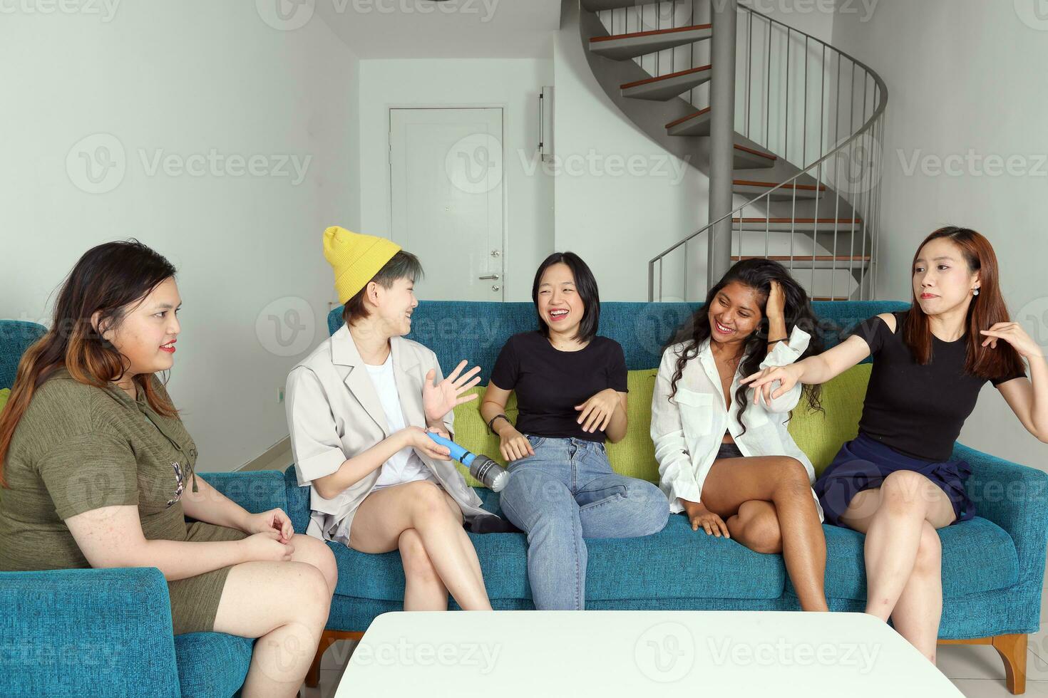 Young Asian woman group talk gossip chat sing party fun enjoy emotion on blue living room sofa photo