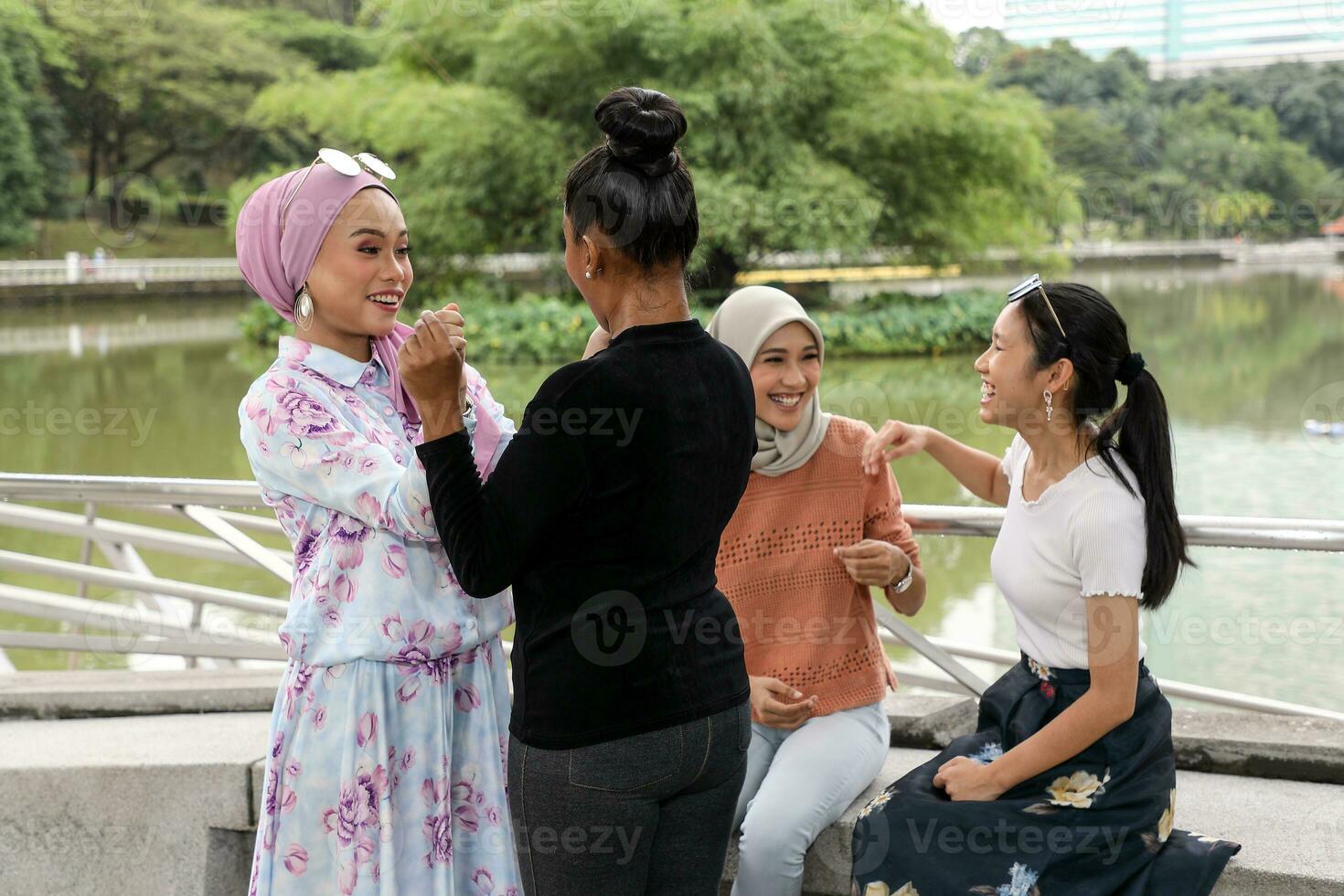 Group of woman Malay Chinese Indian Malaysian  meet and greet talk to each other outdoor green park lake nature photo