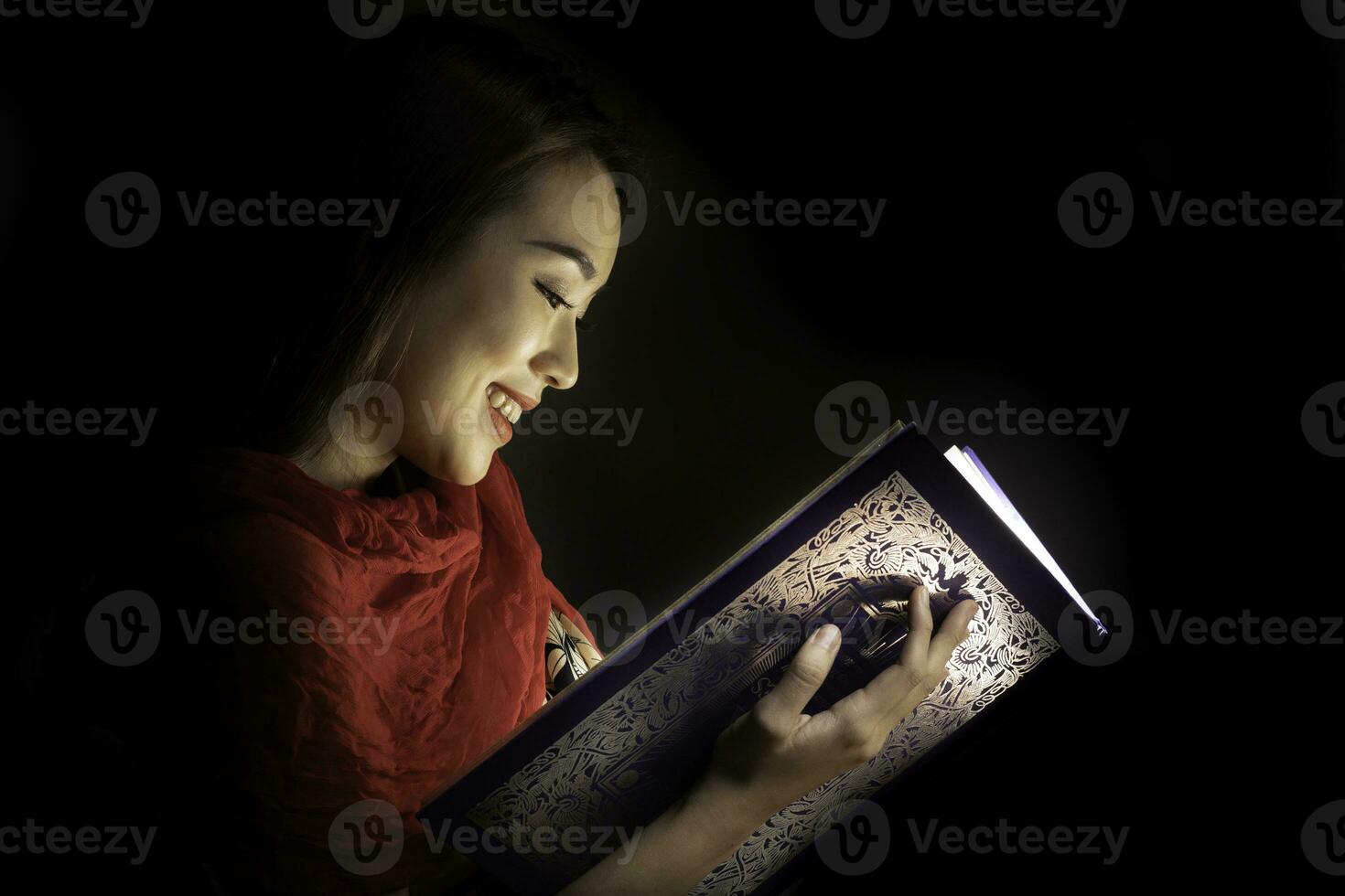 Asian woman opening mystic book box magical light dark background photo