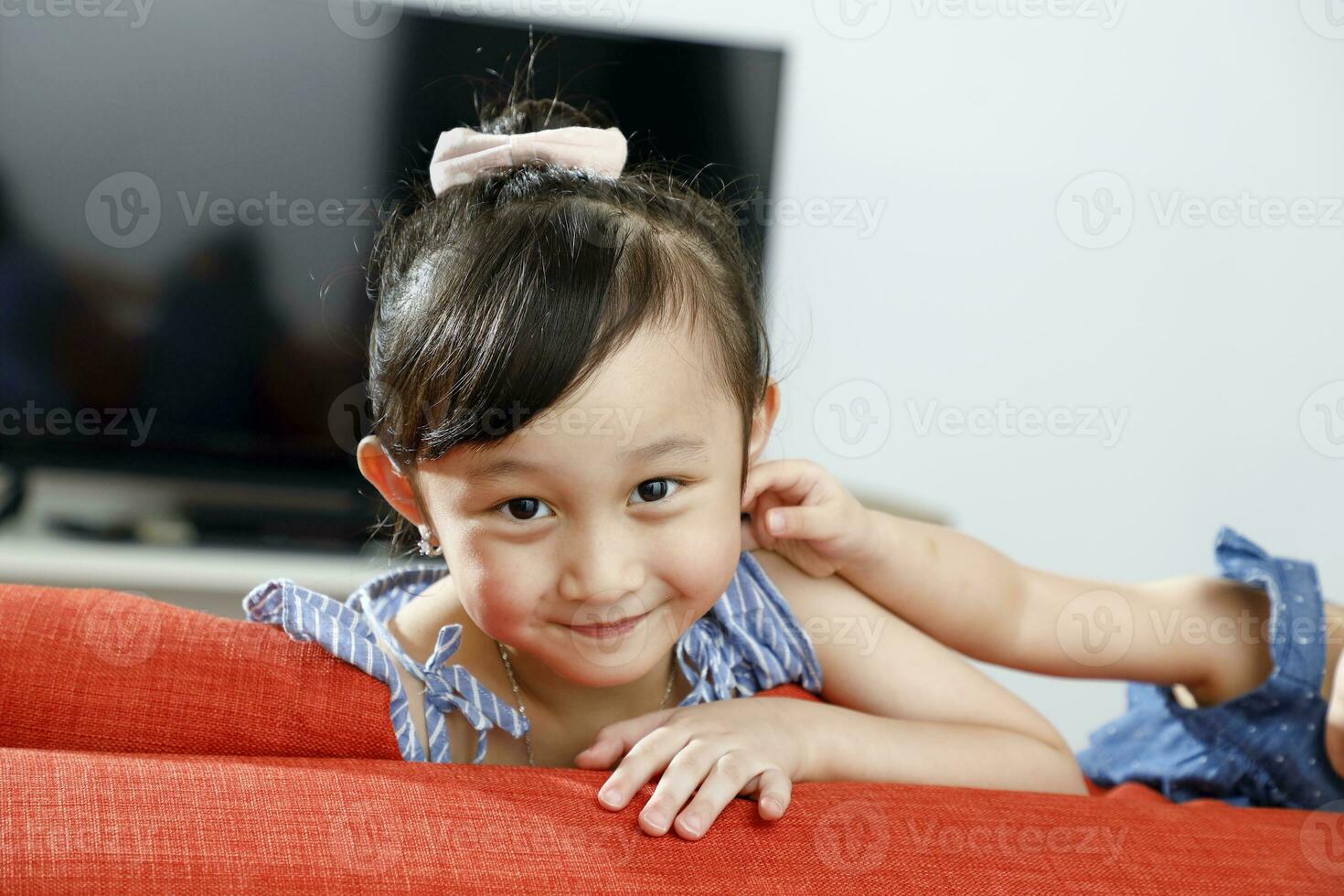 Little girl child looking over the sofa smiling photo