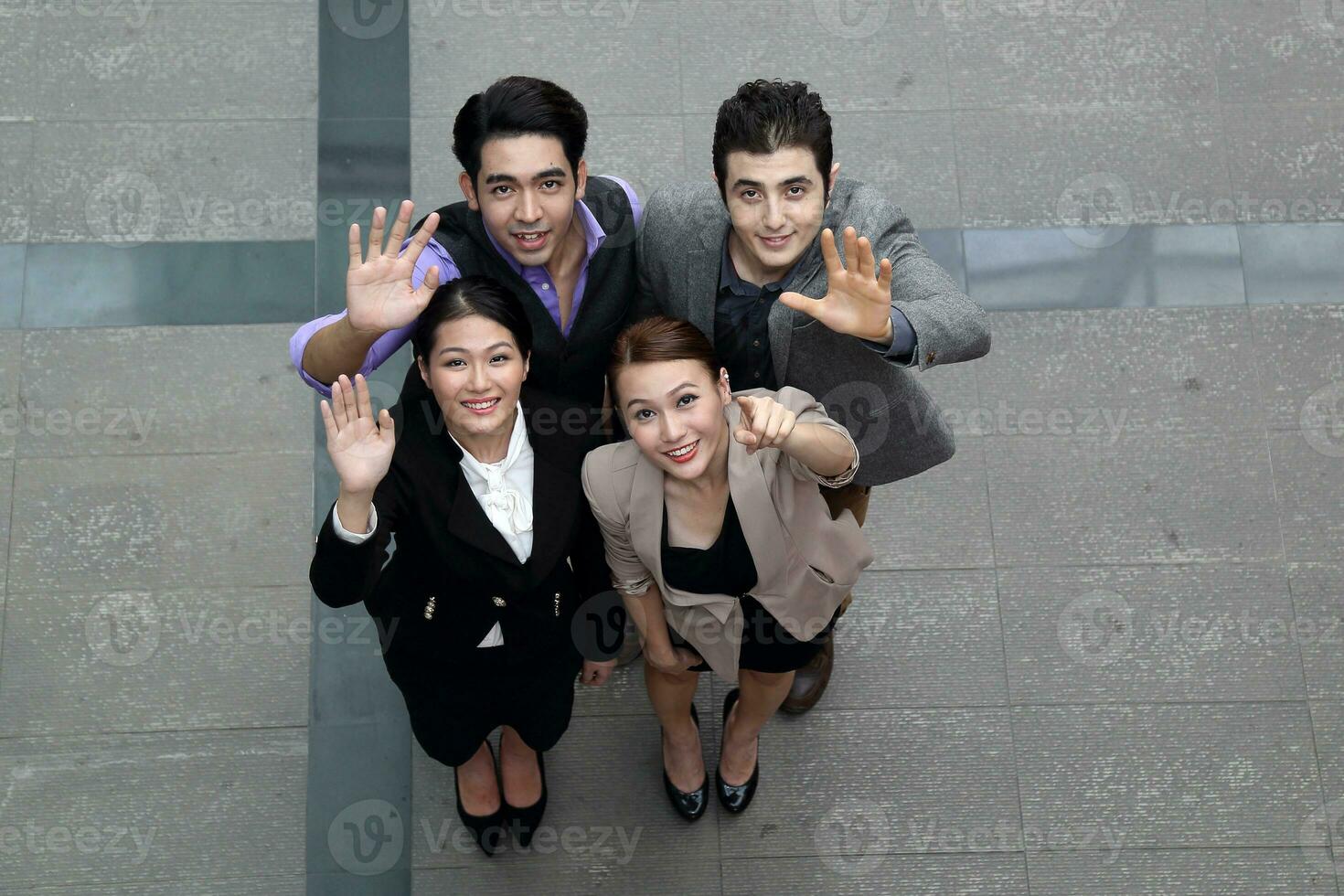 Southeast Asian Middle eastern Caucasian young office business man woman wearing vest suit look up wave hand happy joy outdoor premises floor photo