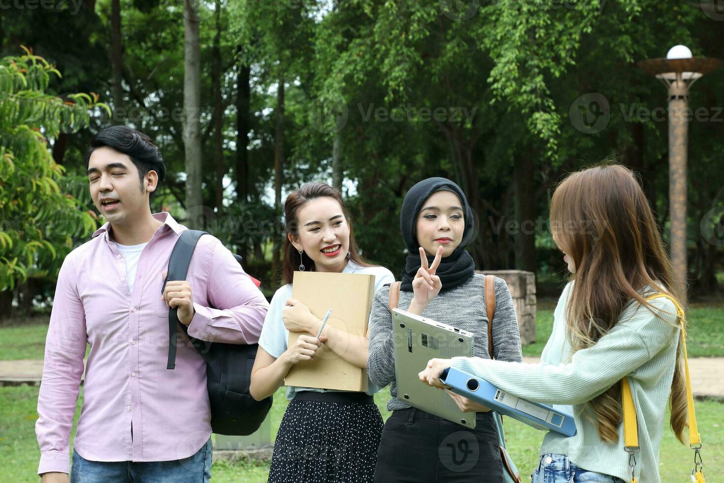 Young asian malay chinese man woman outdoor park  book file folder laptop computer phone sit stand study mingle photo