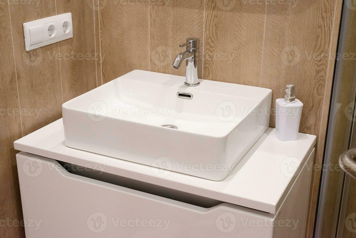 bathroom interior, white sink and soap dispenser photo