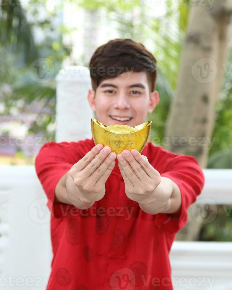 Young south east asian Chinese man woman traditional costume Chinese new year greeting outdoors at temple photo