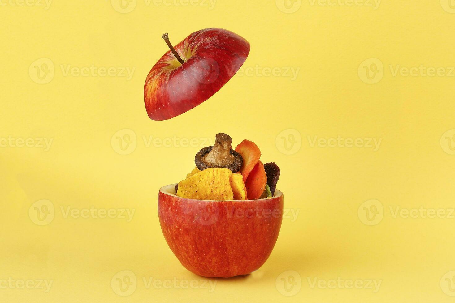 Healthy vegetable chips yellow sweet potato purple sweet potato carrot green radish green beans and shiitake mushrooms in hollow red apple yellow background photo