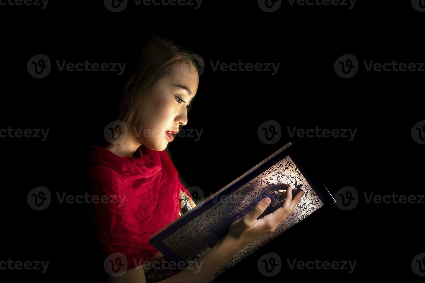 Asian woman opening mystic book box magical light dark background photo