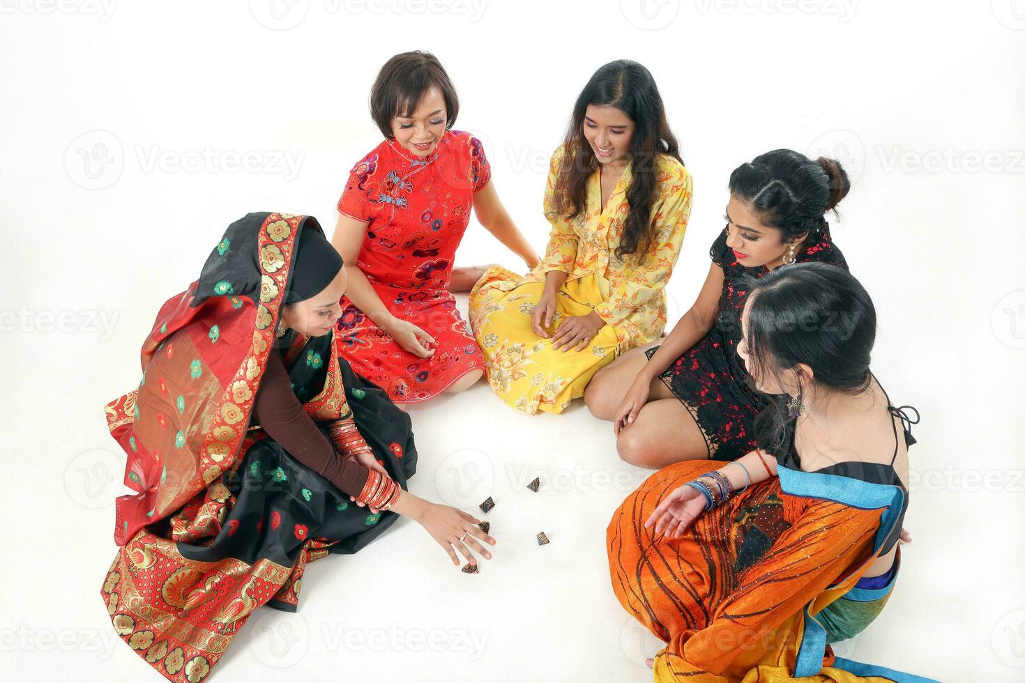 South east Asian Malay Chinese Indian race ethnic origin woman wearing dress costume baju kurung cheongsam samfu kebaya Sharee multiracial community playing Batik Batu Seremban on white background photo