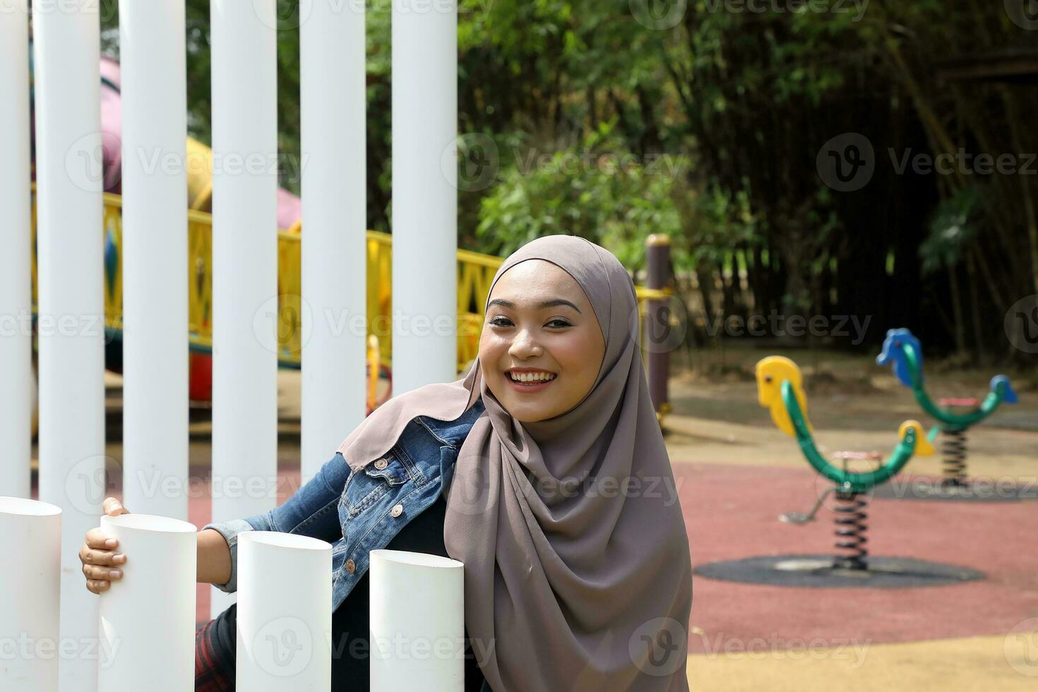 Young Asian Malay man woman outdoor green park walk talk discuss mingle under umbrella photo