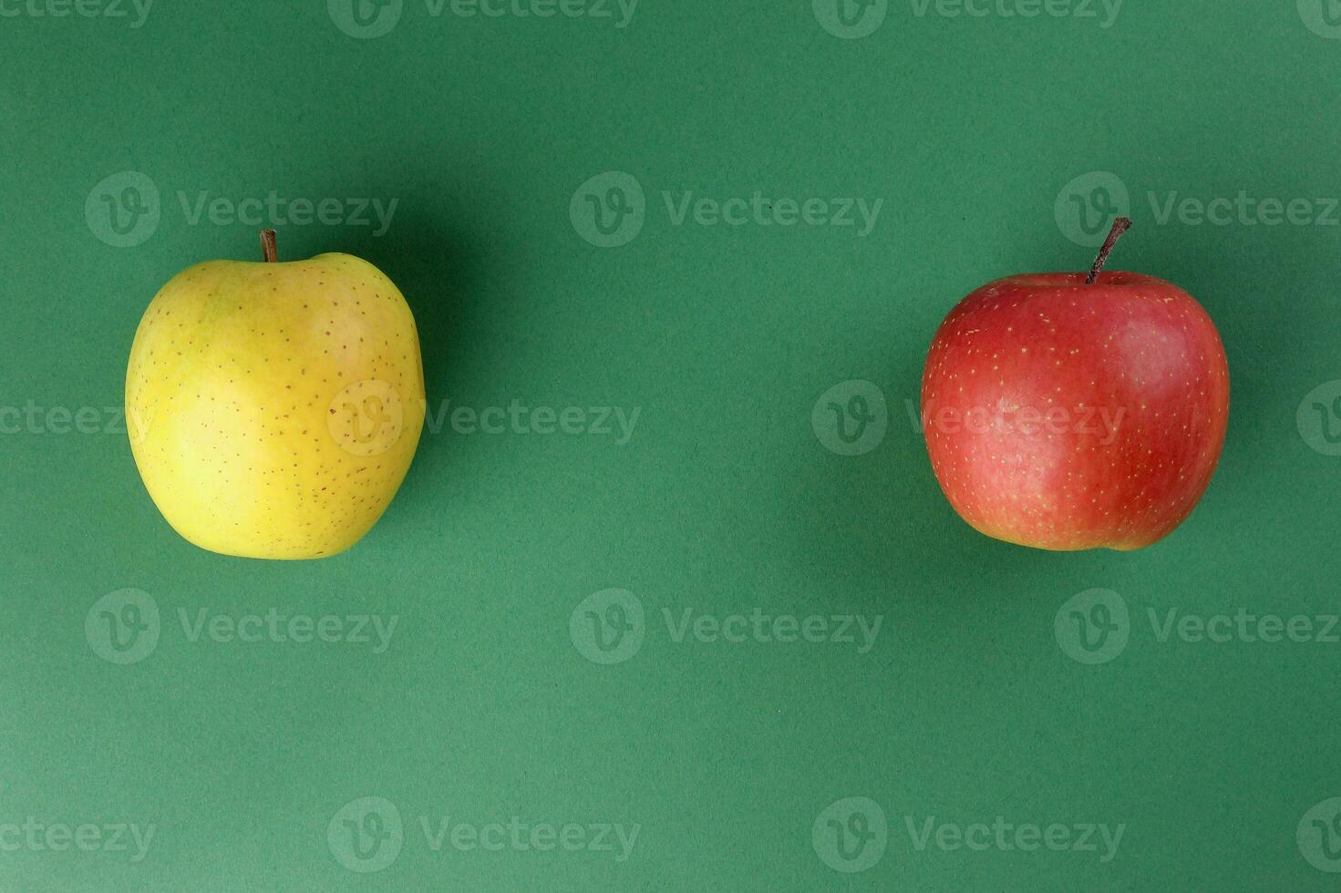 Red yellow green apple on green colour background photo