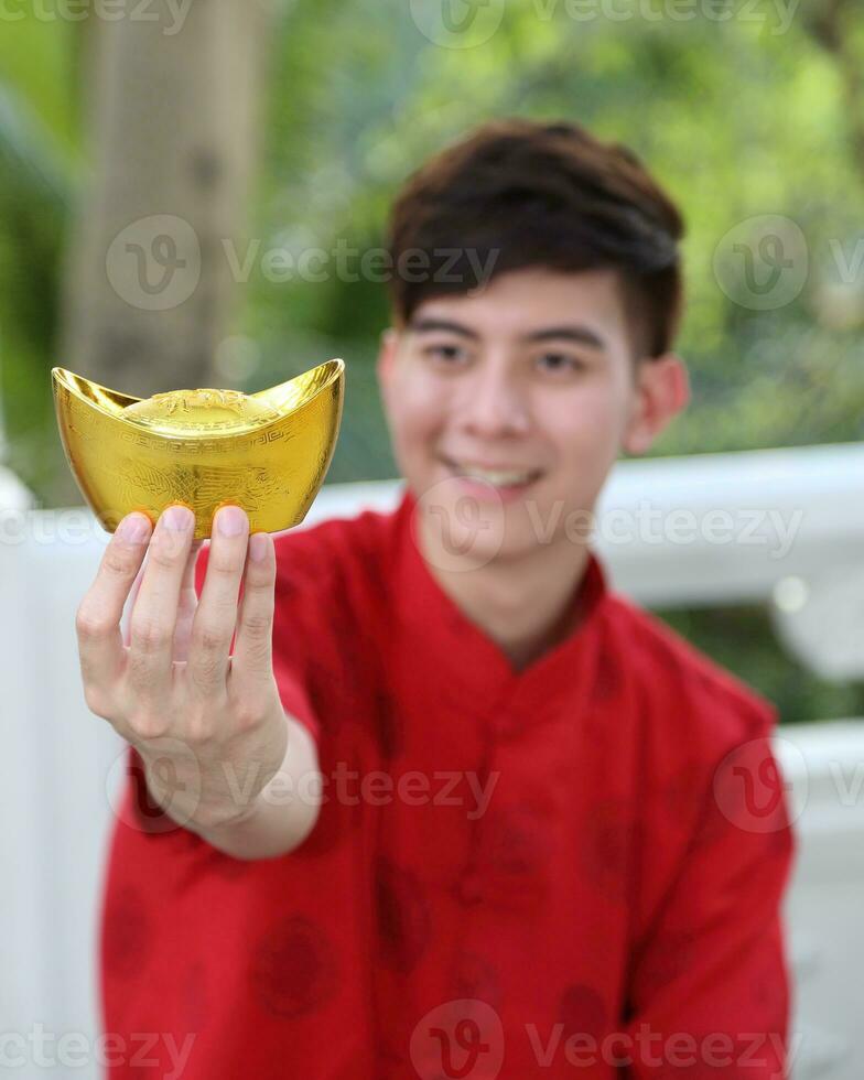 Young south east asian Chinese man woman traditional costume Chinese new year greeting outdoors at temple photo