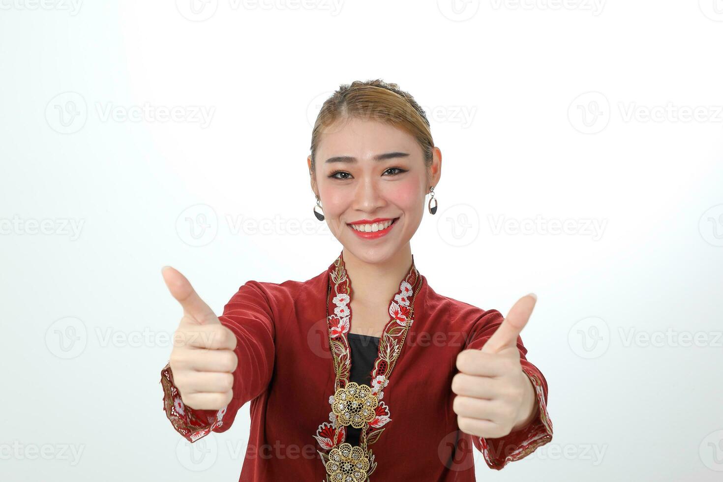 Asian woman traditional red maroon kebaya sharong on white background thumbs up ok focus on face photo